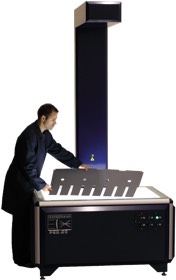 A man standing next to a printer with a large screen.